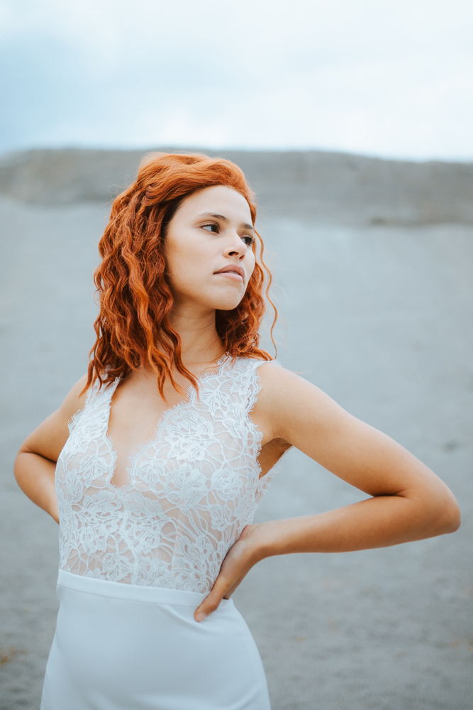 Femme rousse portant une robe de mariée bohème de créateur en dentelle sur-mesure en Bretagne.