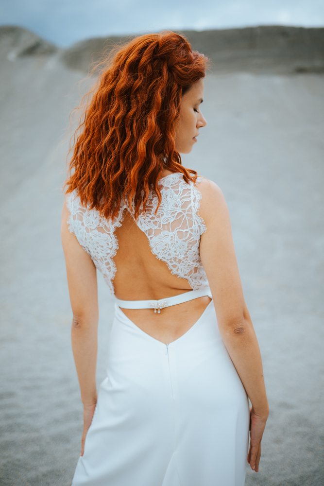 Femme rousse portant une robe de mariée bohème de créateur en dentelle sur-mesure en Bretagne.