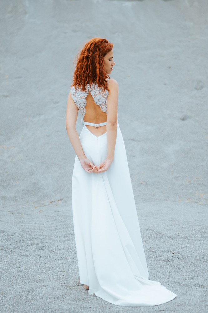 Femme rousse portant une robe de mariée bohème de créateur en dentelle sur-mesure en Bretagne.