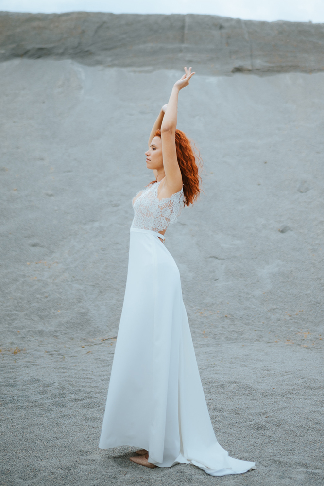 Femme rousse portant une robe de mariée bohème de créateur en dentelle sur-mesure en Bretagne.