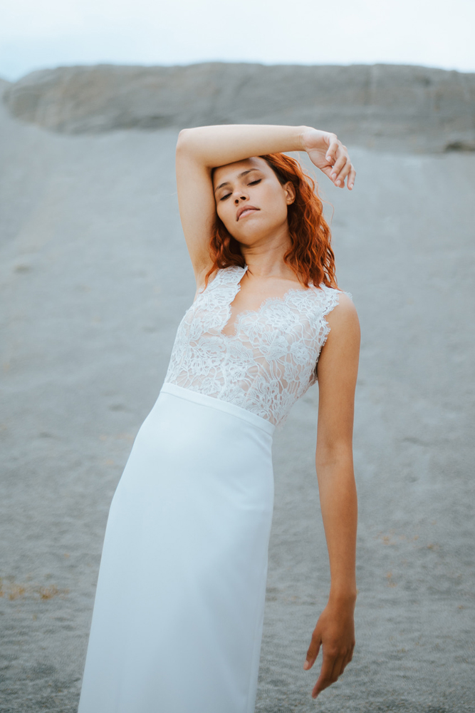 Femme rousse portant une robe de mariée bohème de créateur en dentelle sur-mesure en Bretagne.