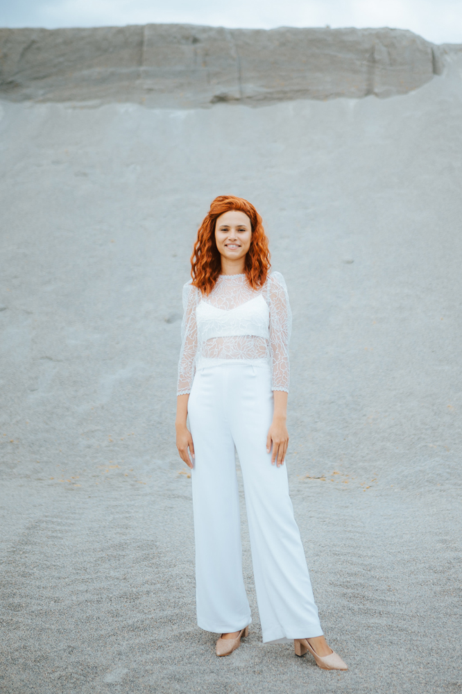 Femme rousse portant une robe de mariée avec pantalon de créateur en dentelle sur-mesure en Bretagne.