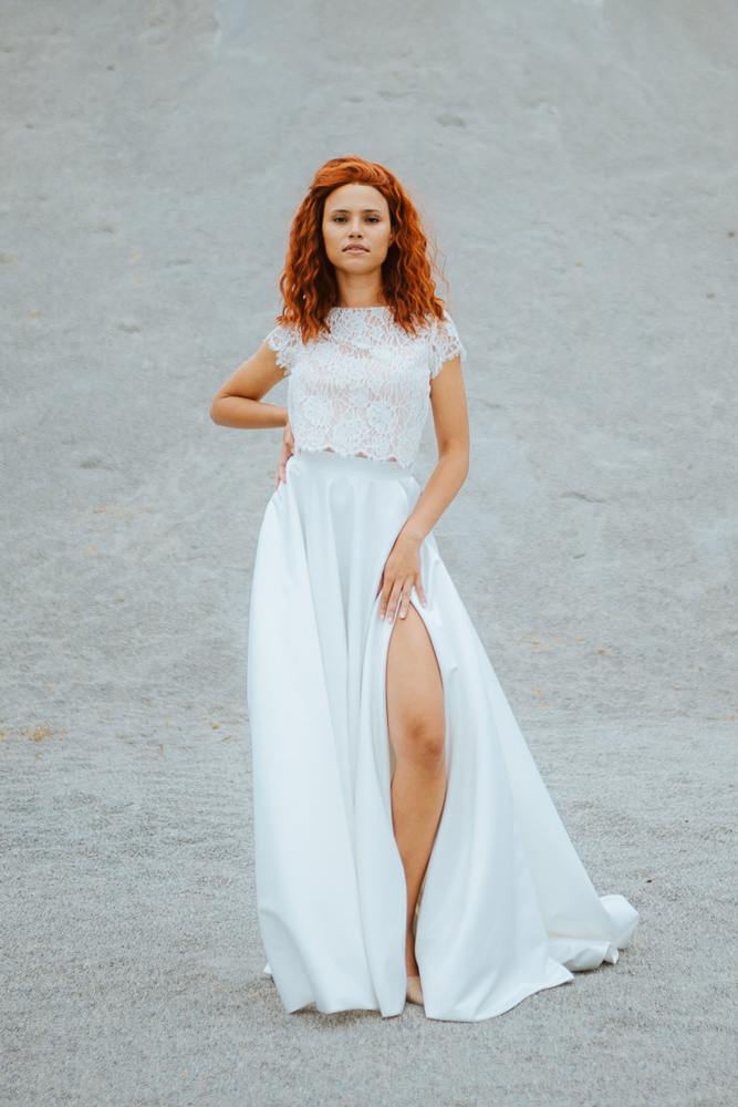 Femme rousse portant une robe de mariée princesse de créateur en dentelle sur-mesure en Bretagne.