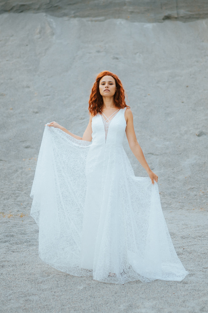 Femme rousse portant une robe de mariée princesse de créateur en dentelle sur-mesure en Bretagne.