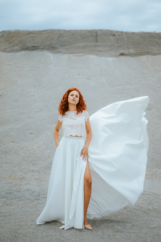 Femme rousse portant une robe de mariée princesse de créateur en dentelle sur-mesure en Bretagne.