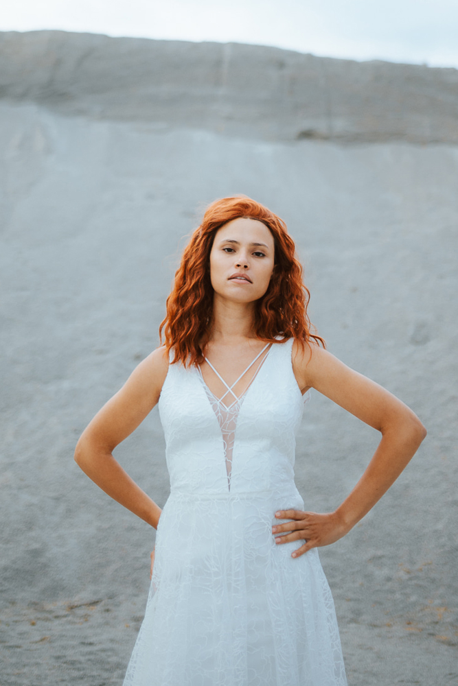 Femme rousse portant une robe de mariée princesse de créateur en dentelle sur-mesure en Bretagne.