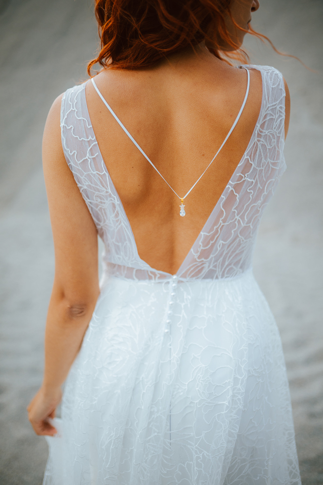 Femme rousse portant une robe de mariée princesse de créateur en dentelle sur-mesure en Bretagne.