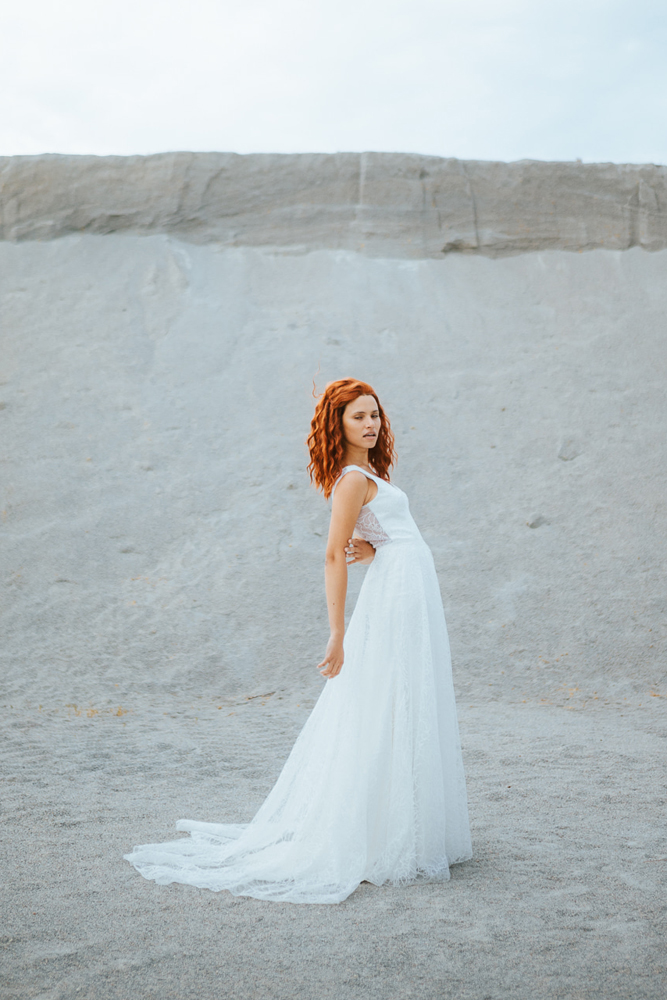 Femme rousse portant une robe de mariée princesse de créateur en dentelle sur-mesure en Bretagne.