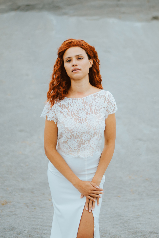 Femme rousse portant une robe de mariée sirène de créateur en dentelle sur-mesure en Bretagne.