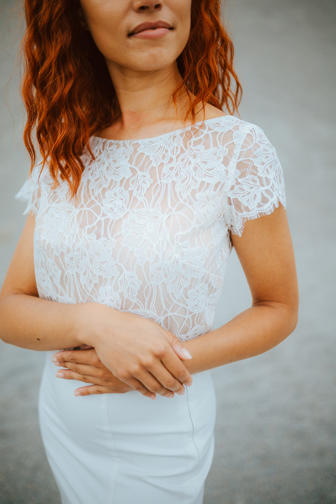 Femme rousse portant une robe de mariée sirène de créateur en dentelle sur-mesure en Bretagne.