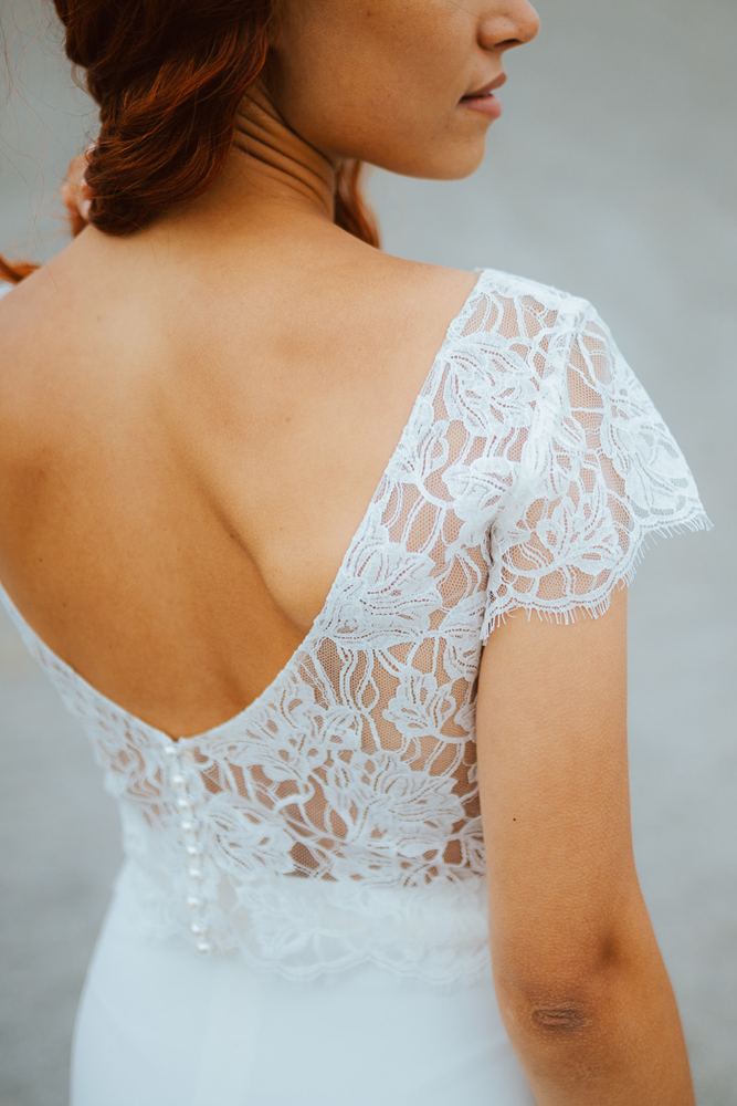 Femme rousse portant une robe de mariée sirène de créateur en dentelle sur-mesure en Bretagne.