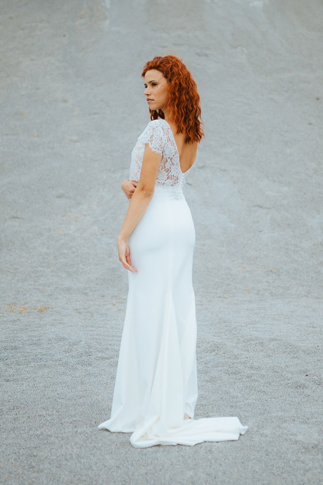 Femme rousse portant une robe de mariée sirène de créateur en dentelle sur-mesure en Bretagne.